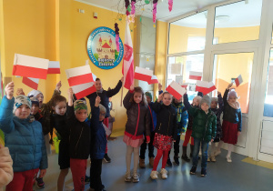 Dzieci z flagami w holu przedszkola